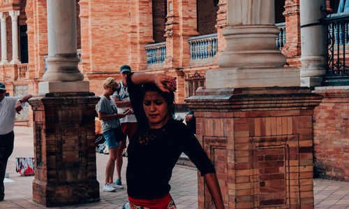 Full length of friends standing at historic building