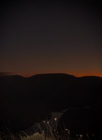 Scenic view of silhouette landscape against sky at night