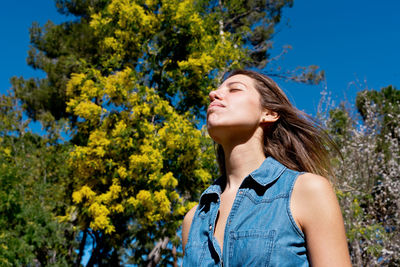 Side view of woman standing against trees