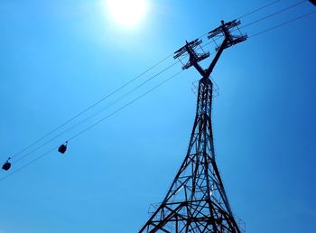 Low angle view of silhouette cranes against clear blue sky
