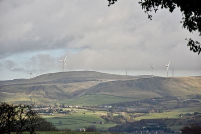 Traditional windmill on field against sky