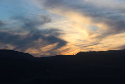 Silhouette of landscape against cloudy sky