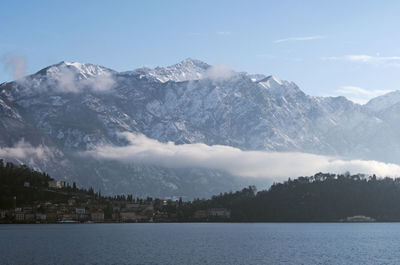 Scenic view of lake by mountains against sky