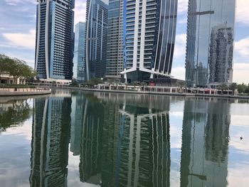 Reflection of buildings in lake against sky