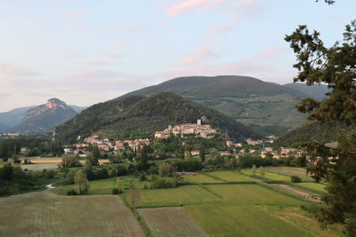 Scenic view of townscape by mountains against sky