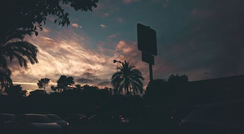 Cars on road against sky during sunset