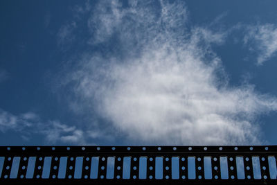 Low angle view of railings against cloudy sky