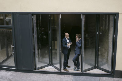 Senior and mid-adult businessman with tablet and cell phone having a meeting