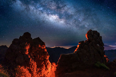 Low angle view of rock formations against sky at night