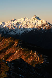 Snow capped mountains lighted by sunrise