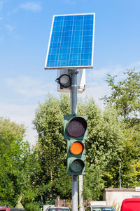 Low angle view of stoplight against sky