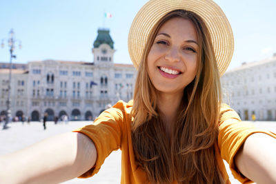 Tourism in europe. self portrait of smiling young tourist woman visiting trieste, italy.