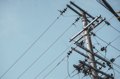 Low angle view of electricity pylon against clear sky