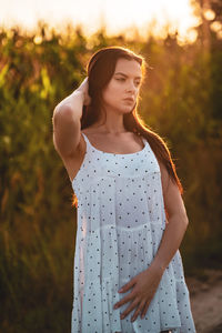 Young woman standing against plants