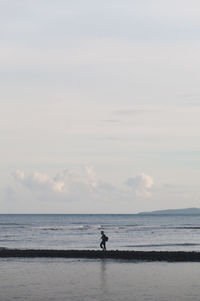 Man standing on beach against sky