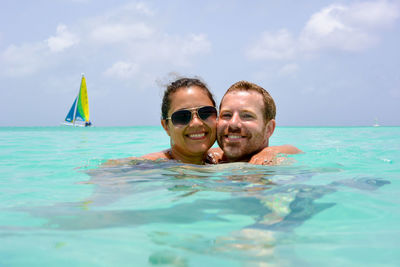 Portrait of smiling couple swimming in sea
