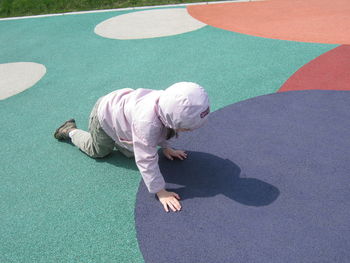 Full length of child crawling on floor at playground