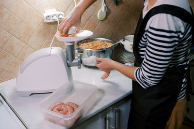 Midsection of man preparing food in kitchen