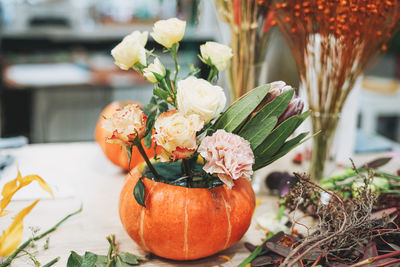 Diy autumn flower arrangement bouquet in pumpkin, florist at work, floristry studio