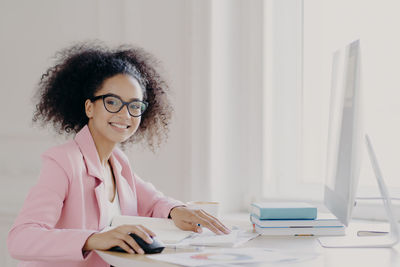 Portrait of smiling businesswoman working on computer
