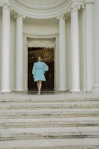 Rear view of woman standing by building