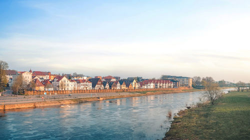 View of river by town against sky