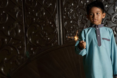 Malay boy playing fireworks sparkler during ramadan festival 