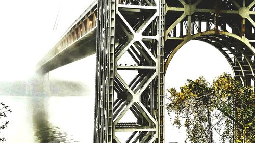 Low angle view of bridge over river against sky