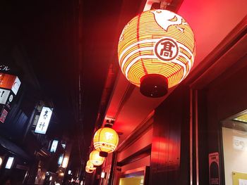 Low angle view of illuminated lanterns hanging at night