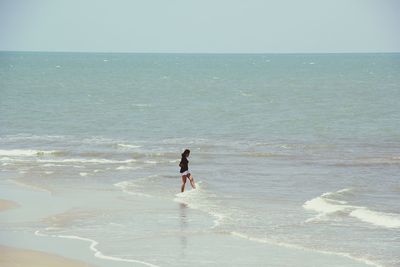 People on beach against clear sky