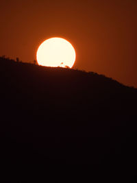 Low angle view of silhouette mountains against sky during sunset