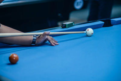 Midsection of woman playing pool