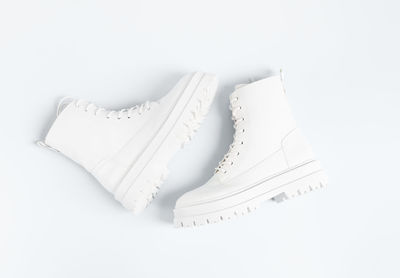 White demi-season boots made of eco-leather with fasteners, laces on a white.