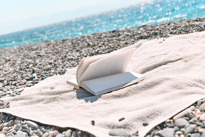 Open book on the pebble beach. concept of reading and relaxing in summer vacation. beach literature.