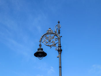 Low angle view of street light against blue sky