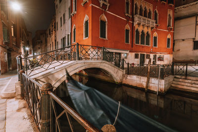 Arch bridge over canal amidst buildings in city