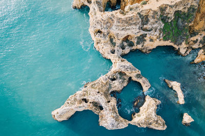 Aerial view of rock in sea against sky