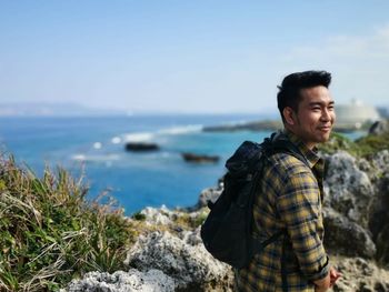 Smiling man standing against sea