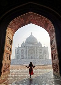 Rear view of woman standing at historical building