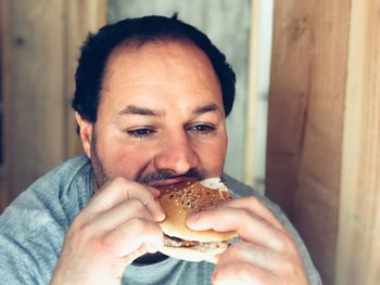 Close-up of man eating burger