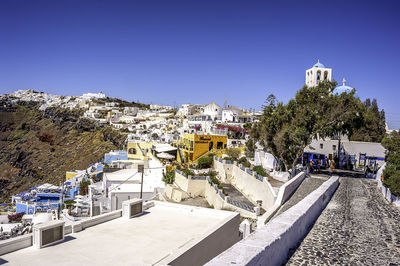 Buildings in town against clear blue sky