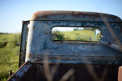 Close-up of abandoned land vehicle against sky