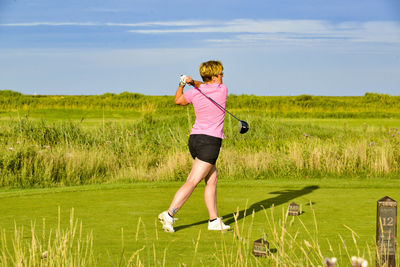 Full length of woman playing golf against sky