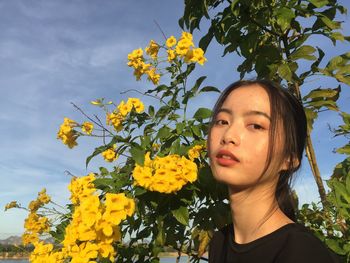 Portrait of woman against yellow flowering plants