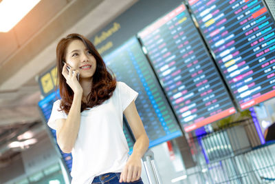 Portrait of smiling young woman using mobile phone