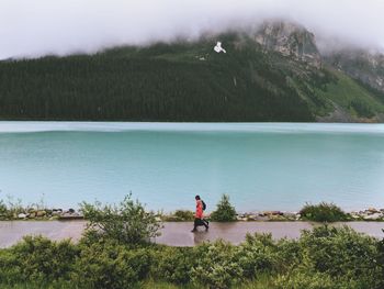 Man looking at lake against mountain