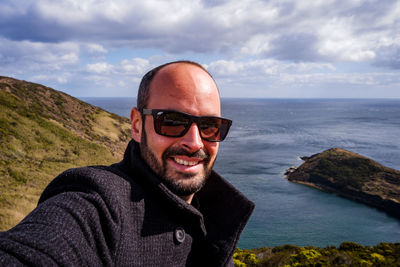 Portrait of smiling man in sea against sky