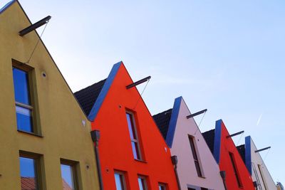 Low angle view of multi colored row houses against clear sky