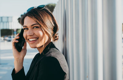 Portrait of smiling young woman using mobile phone