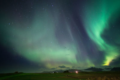 Scenic view of landscape against star field at night